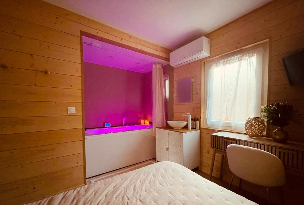 een slaapkamer met een groot raam met paarse verlichting bij Caprice Gruissanais Suite avec Spa privatif in Gruissan