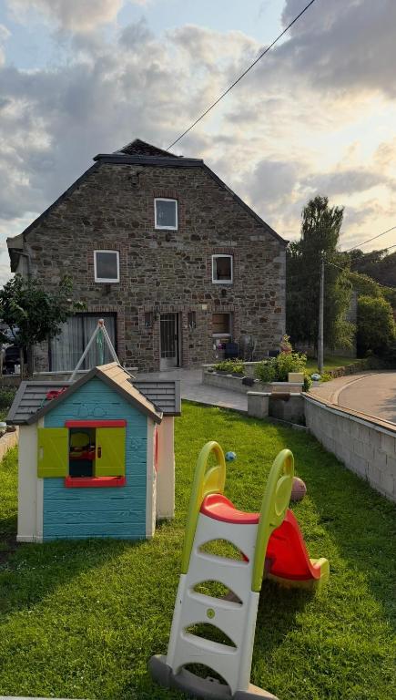 two childrens play equipment in front of a house at Famenne Escape in Marche-en-Famenne