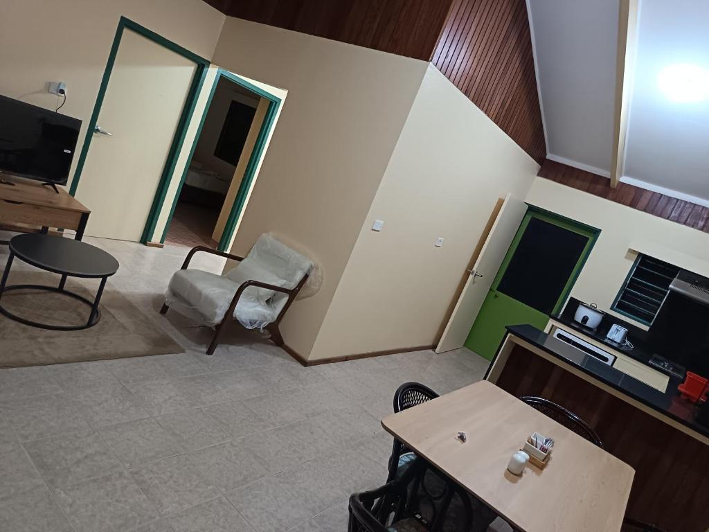 Una sala de estar con una mesa y sillas y un televisor. en LG Palms, en Sigatoka