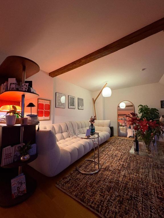 a living room with a white couch and a table at Cosy room in attic flat in the center of Zurich in Zürich