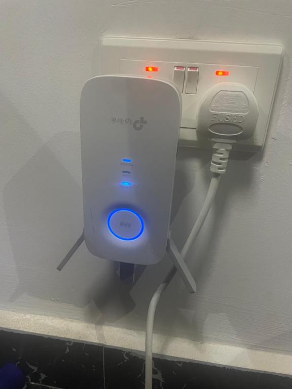 a white phone is plugged into a wall at Nick Jaaks Courtyard-Single Room in Accra