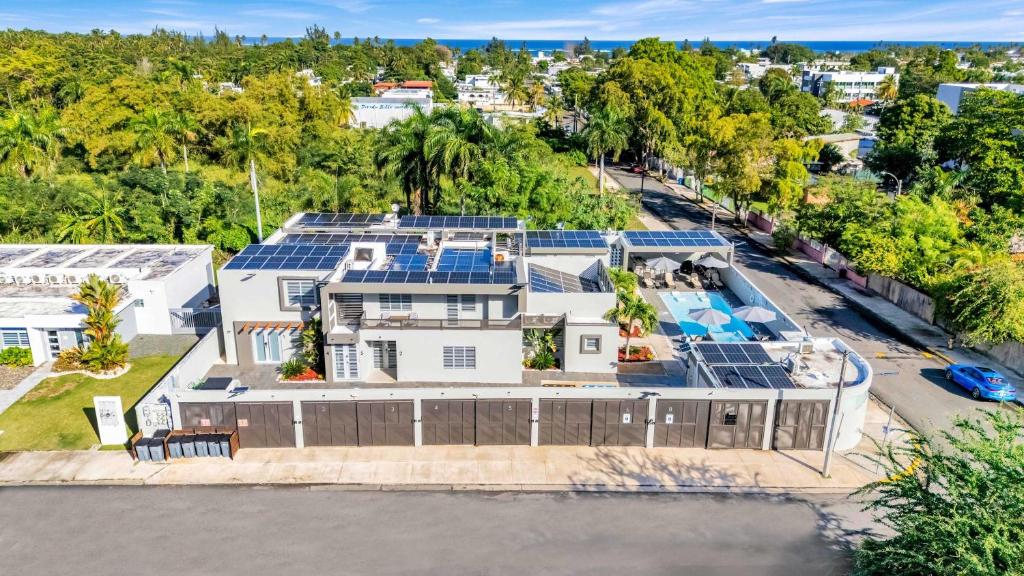 una vista aérea de una casa con paneles solares en su techo en AQUA Ville Moderna - Serene 16BR Coastal Haven Villa with Pool, en Dorado