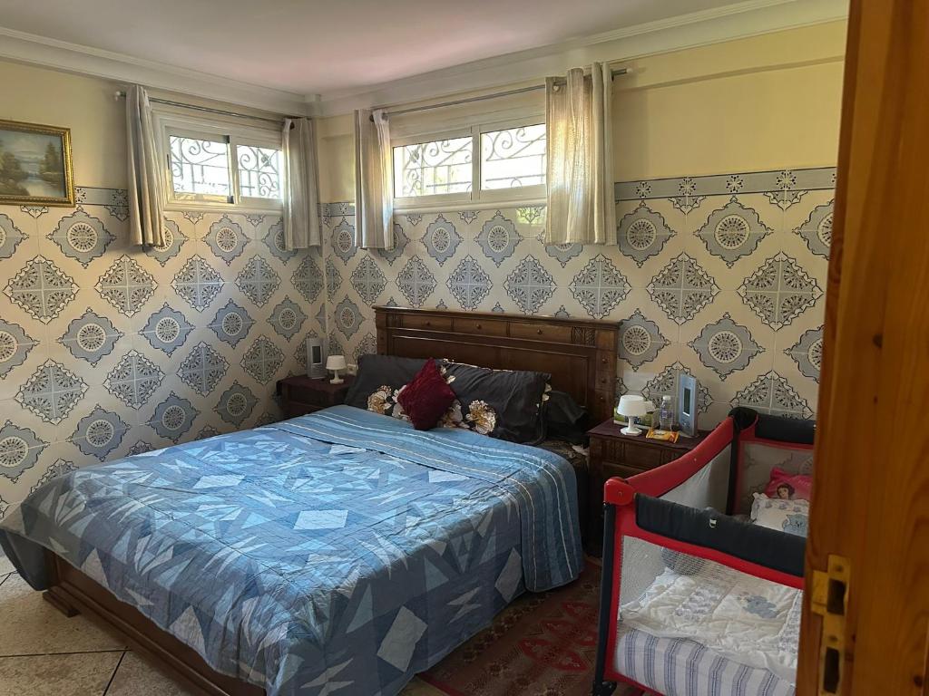 a bedroom with a bed and two windows at Dream House Sidi Rahal Beach in Sidi Rahal