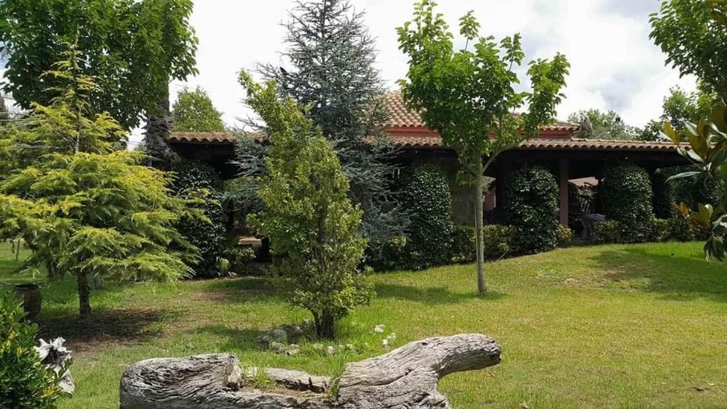 a house with a log in front of a yard at Lea's Ηοme in Kourouta