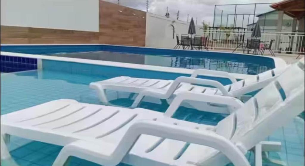 巴纳伊巴Casa em Parnaíba的游泳池里的一组白色躺椅
