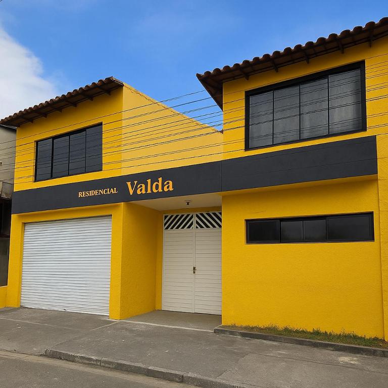 a yellow building with two garage doors at Suites Novas in Cabo Frio