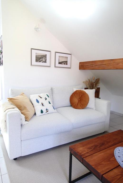 a white couch in a living room with a table at Les Cimes - Le Tholy in Le Tholy