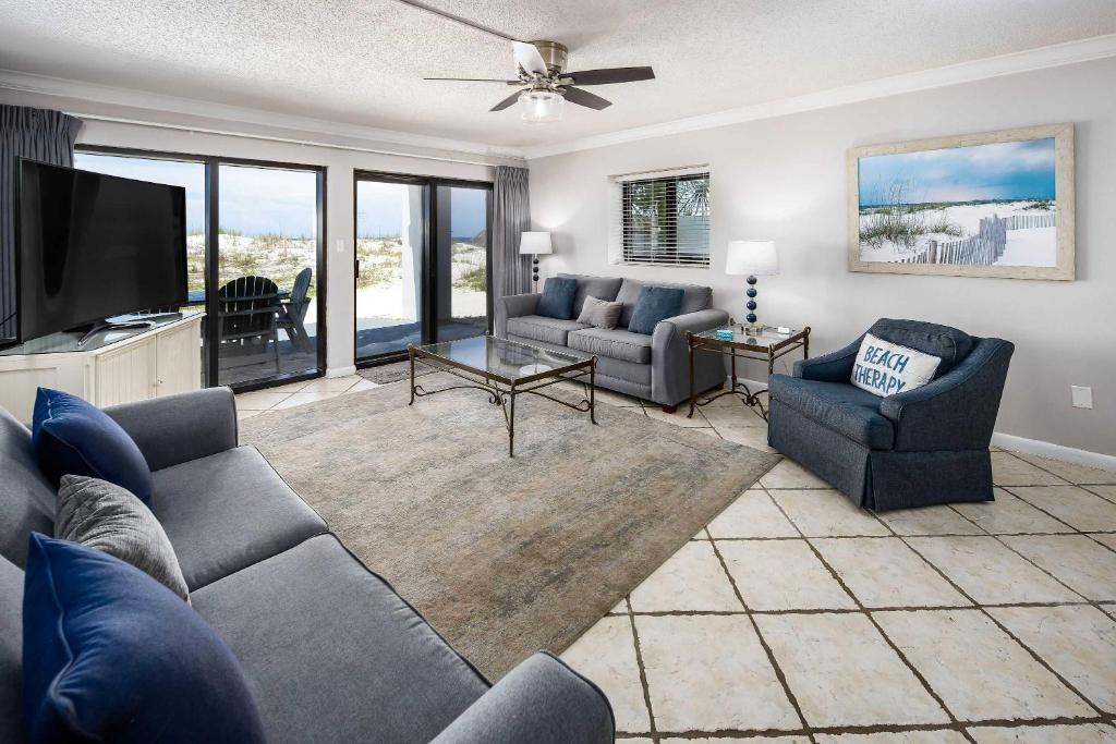 un soggiorno con divani e TV a schermo piatto di Surf Dweller 112 Large gulf front condo a Fort Walton Beach