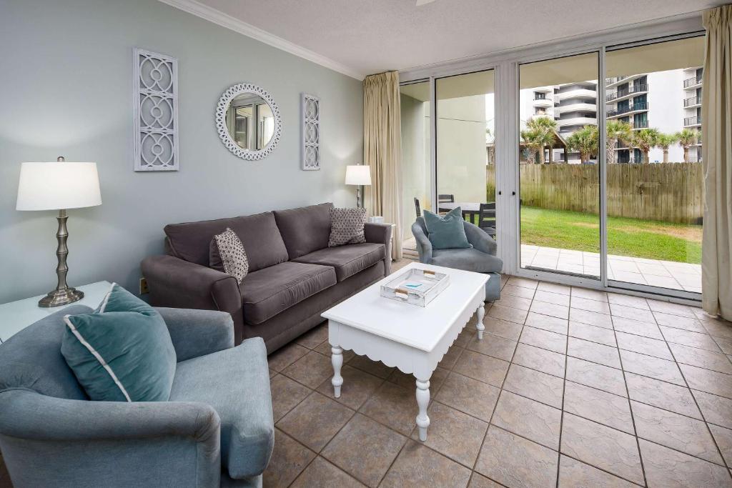 un soggiorno con un divano, sedie e un tavolo di Waters Edge 102 Large 1st floor condo a Fort Walton Beach