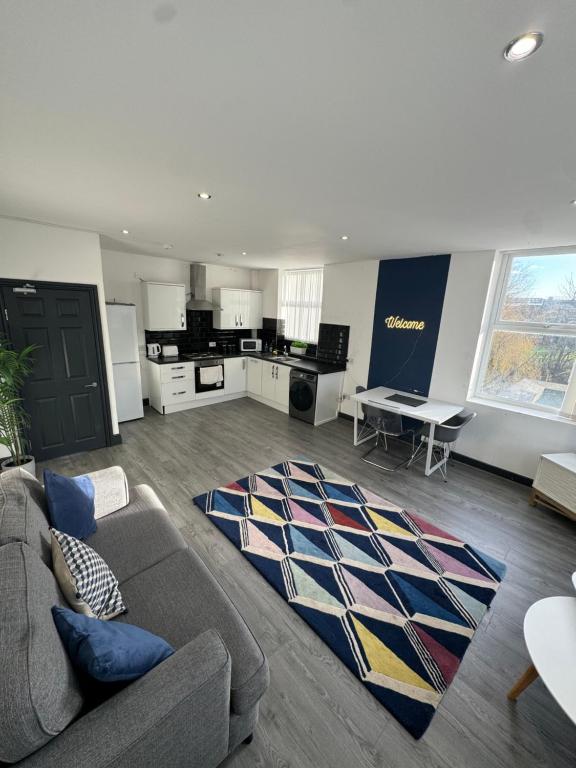 ein Wohnzimmer mit Sofa und eine Küche in der Unterkunft The residency appartment's in Litherland