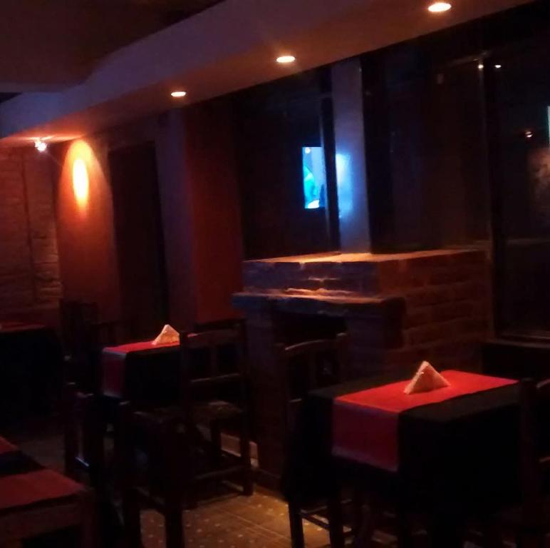 a dining room with red tables and chairs and a window at Kilometro Cero in La Quiaca