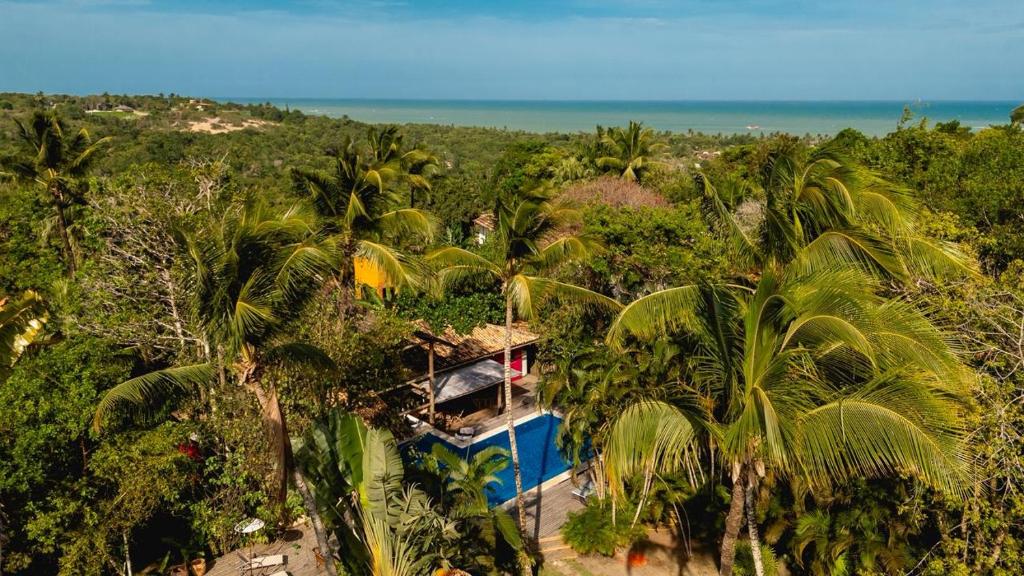 Pousada Hibisco في ترانكوسو: اطلالة جوية على منتجع فيه نخيل والمحيط