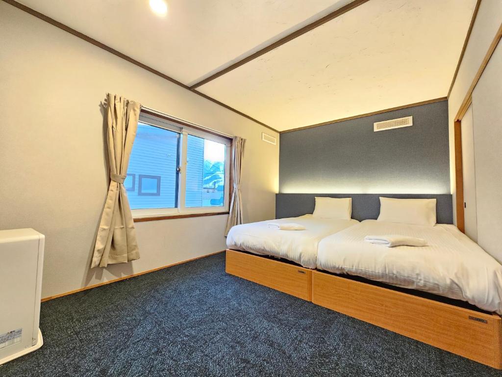 una camera da letto con un letto e una finestra di furano lavender house a Furano