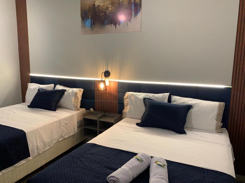 een kamer met 2 bedden en een lamp aan de muur bij 101-Quarto Pousada Hg in Vila Nova do Sul