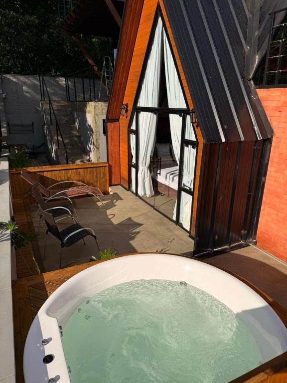 a small house with a tub in a backyard at Chales da Trilha in Penha
