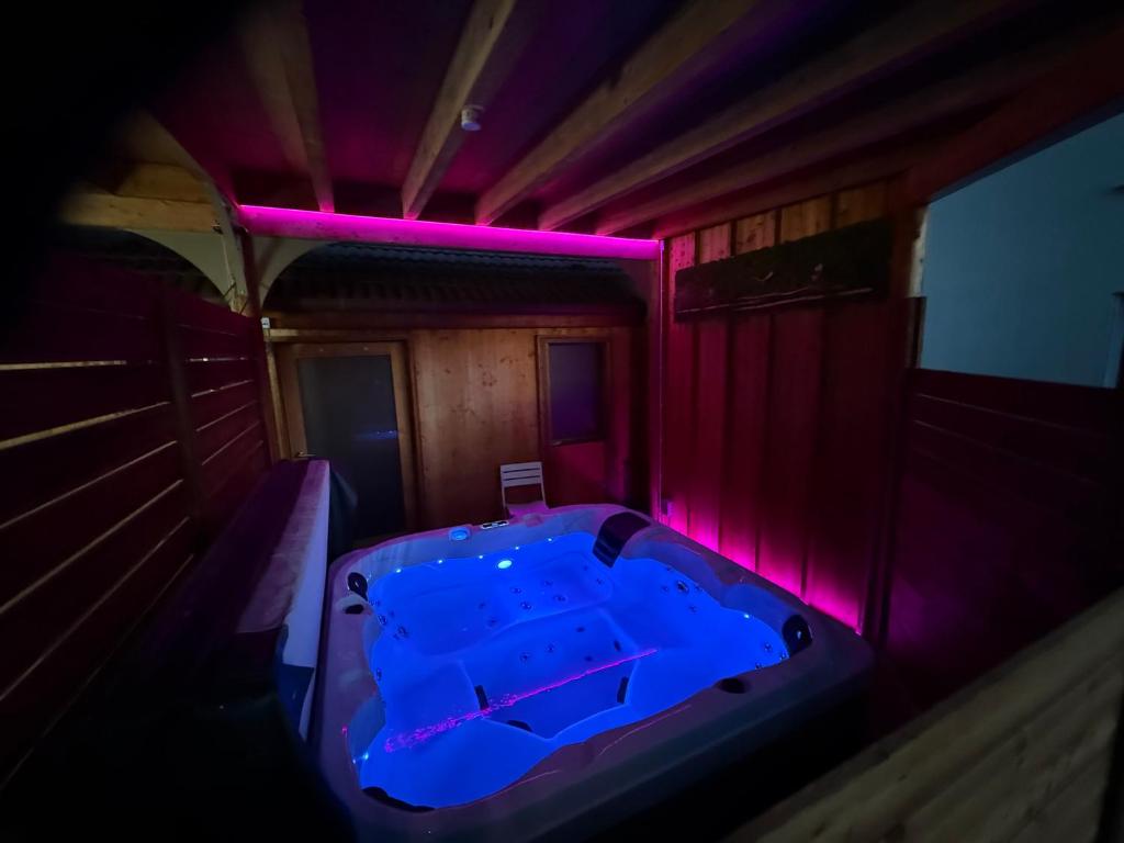 ein Zimmer mit einem Whirlpool mit violetten Lichtern in der Unterkunft Hôtel entièrement privatisé avec spa in Rupt-sur-Moselle
