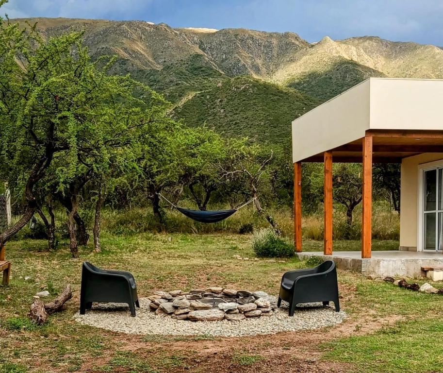Eine Hängematte hängt über einer Feuerstelle im Garten. in der Unterkunft Casa de montaña in Cortaderas