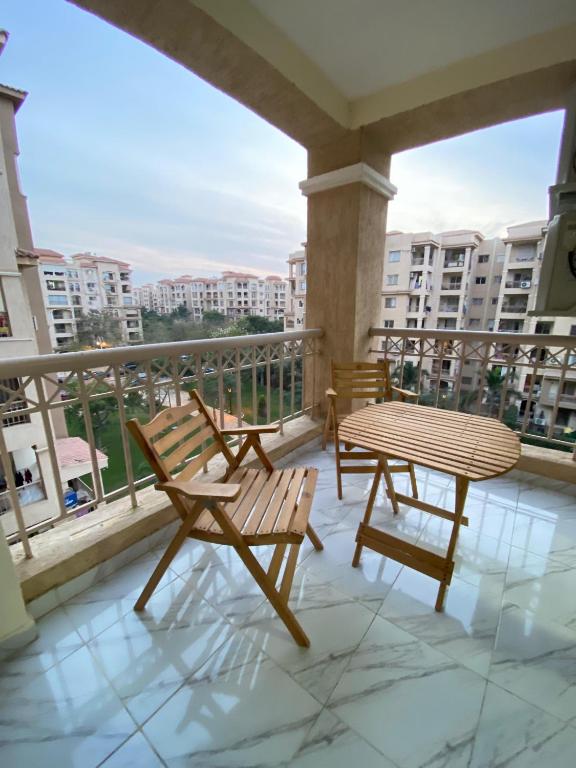 a patio with two chairs and a table on a balcony at Central Park hotel apartment in Madinaty