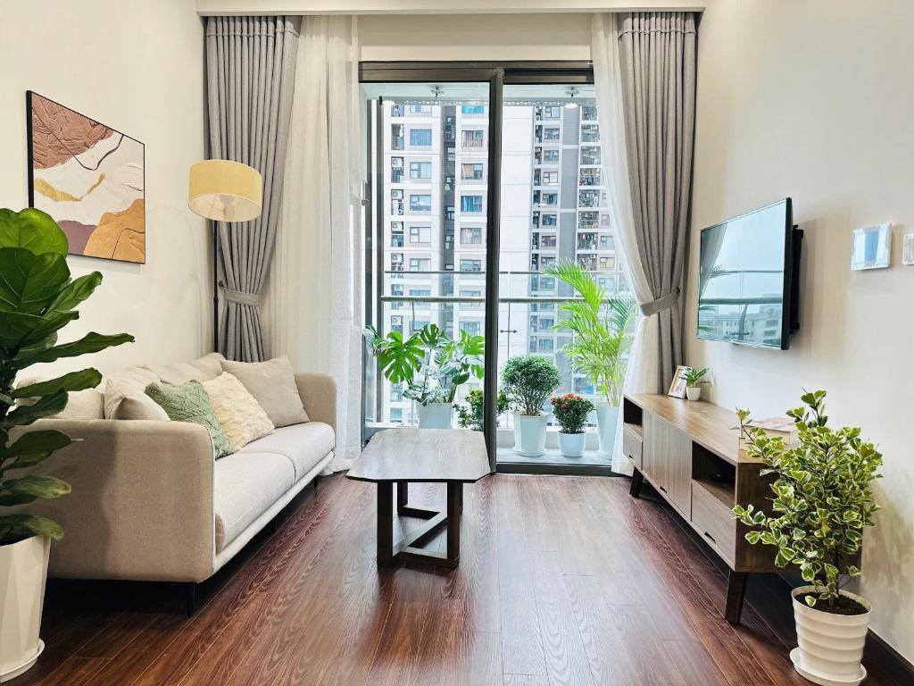 een woonkamer met een bank en een tv bij Sunny Residence Masteri Waterfront, Hà Nội in Gia Lâm Pho