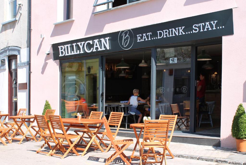 um grupo de mesas e cadeiras em frente a um restaurante em Billycan em Tenby