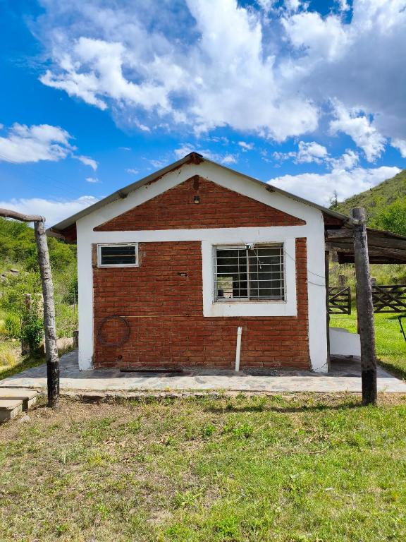 a small brick house with a window in a field at CABAÑAS CAMPO CHICO in Trapiche