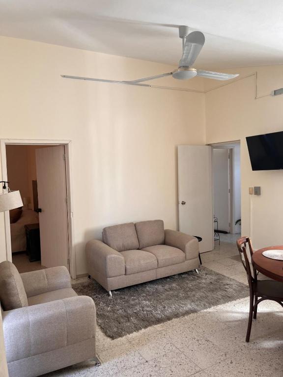 a living room with a couch and a table at Apartment in Merida in Mérida
