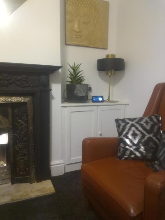 een woonkamer met een bank en een open haard bij Terrace cottage in Blackpool