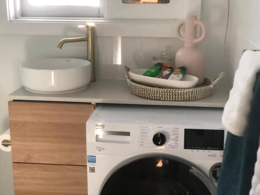 een wasmachine in een keuken met een wastafel bij Pet Friendly Acer Arena Accommodation in Sydney