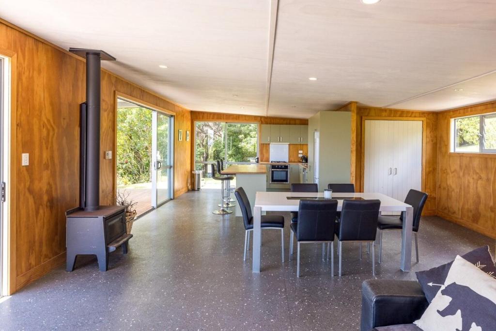 sala de estar con mesa y fogones en Lookout Landing by Waiheke Pure, en Waiheke Island