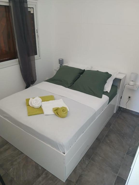 a white bed with towels on it in a room at Bungalow AN KAN LA in Capesterre