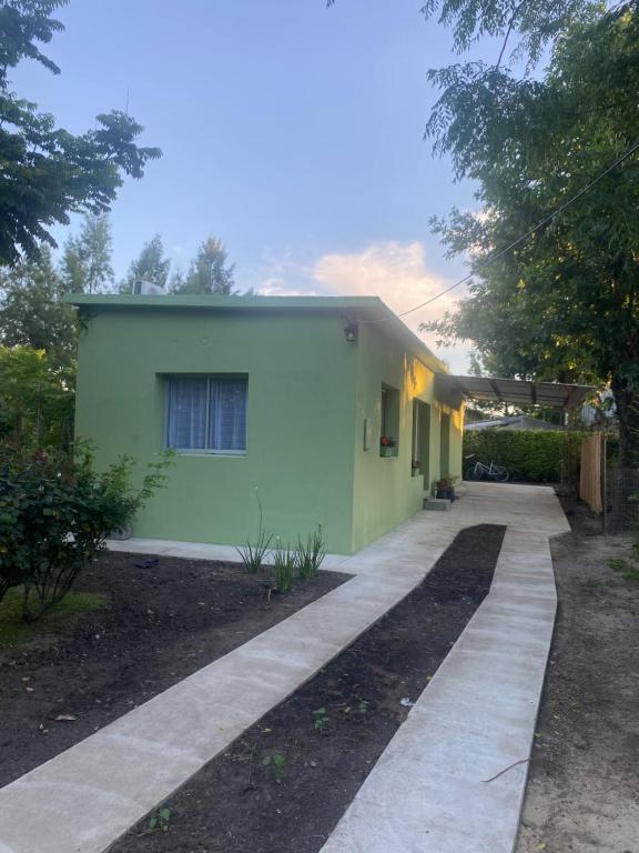 a green house with a walkway in front of it at La Camelia in Juan L. Lacaze