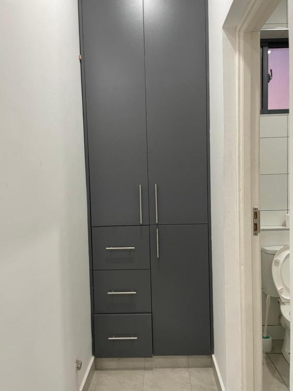 une salle de bains avec toilettes et une armoire haute dans l'établissement Coral Sands - BriSta Stays, à Mombasa