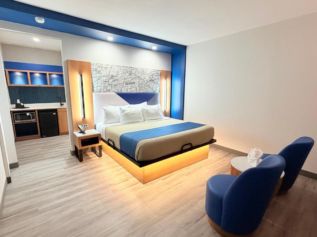 a hotel room with a bed and a kitchen at Crystal Inn - NorthWest - 290 in Houston