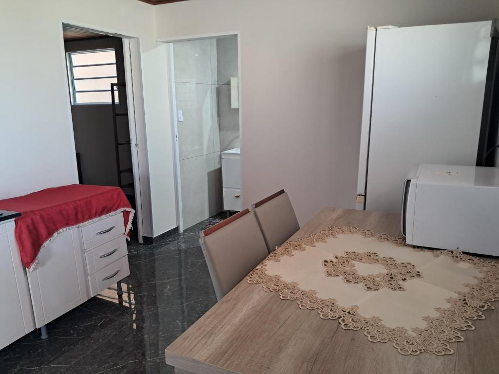 a dining room with a table and a refrigerator at AP BEIRA MAR 01 QUARTo in Jaguaruna
