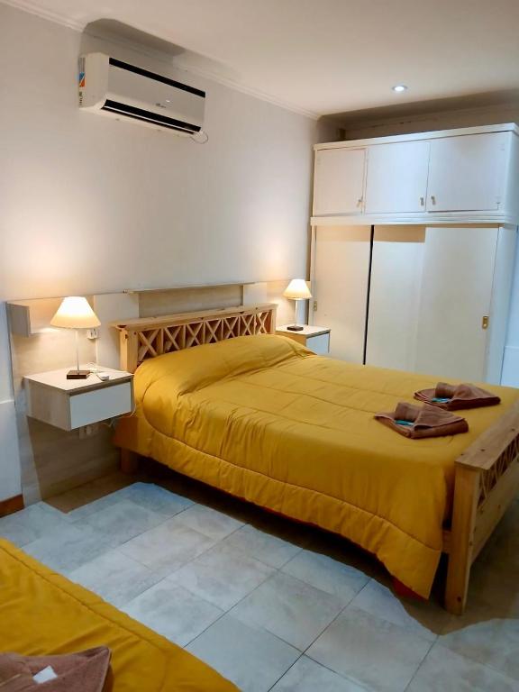une chambre avec un lit avec une couverture jaune dans l'établissement Dpto Céntrico con Asador, à Chilecito