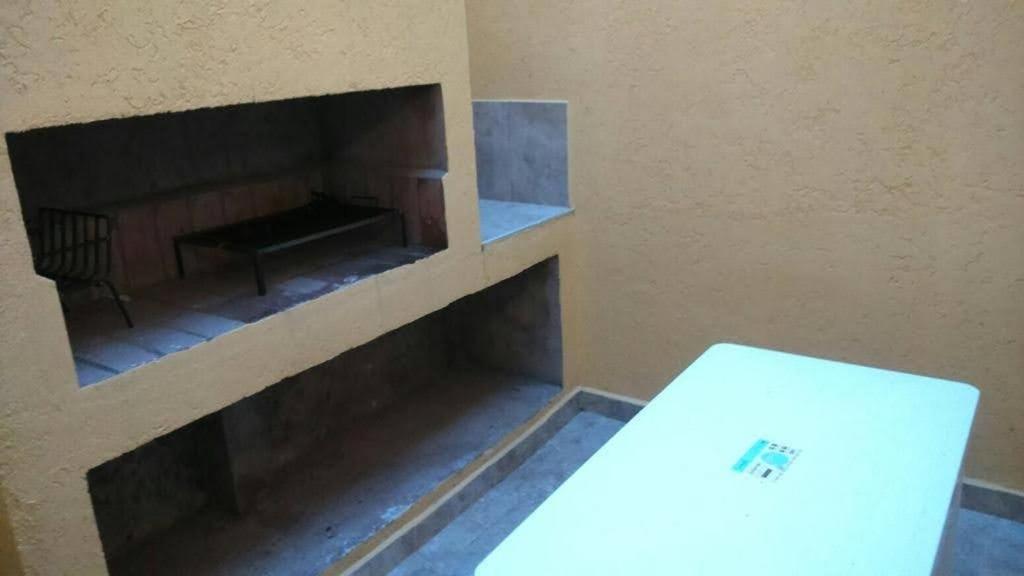 ein Zimmer mit Kamin, Tisch und Laptop in der Unterkunft Complejo Solares in Villa Carlos Paz