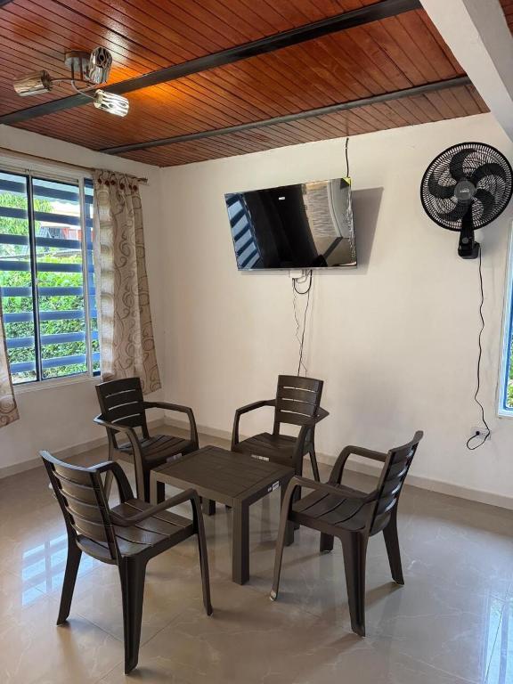 Un comedor con mesa y sillas y un televisor. en Cambulos 3, en Acacías