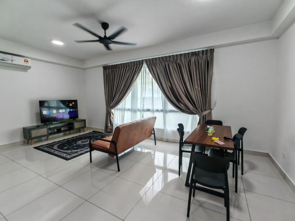 a living room with a table and chairs and a television at MIRAI Residences in Kajang