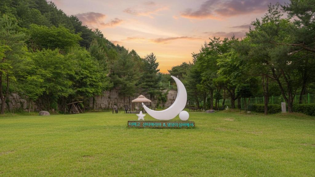 a statue of a moon sitting in the middle of a field at Gapyeong Santa Maria Dog-friendly Privat in Gapyeong