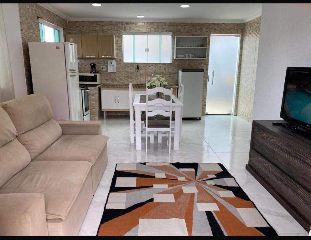 a living room with a couch and a table and a kitchen at Casa independente em tuncuns in Búzios