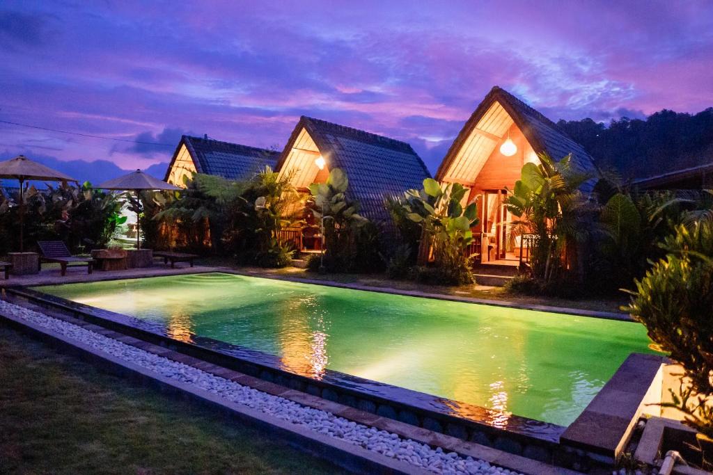 a swimming pool in front of a house at The Caldera Villas in Kubupenlokan