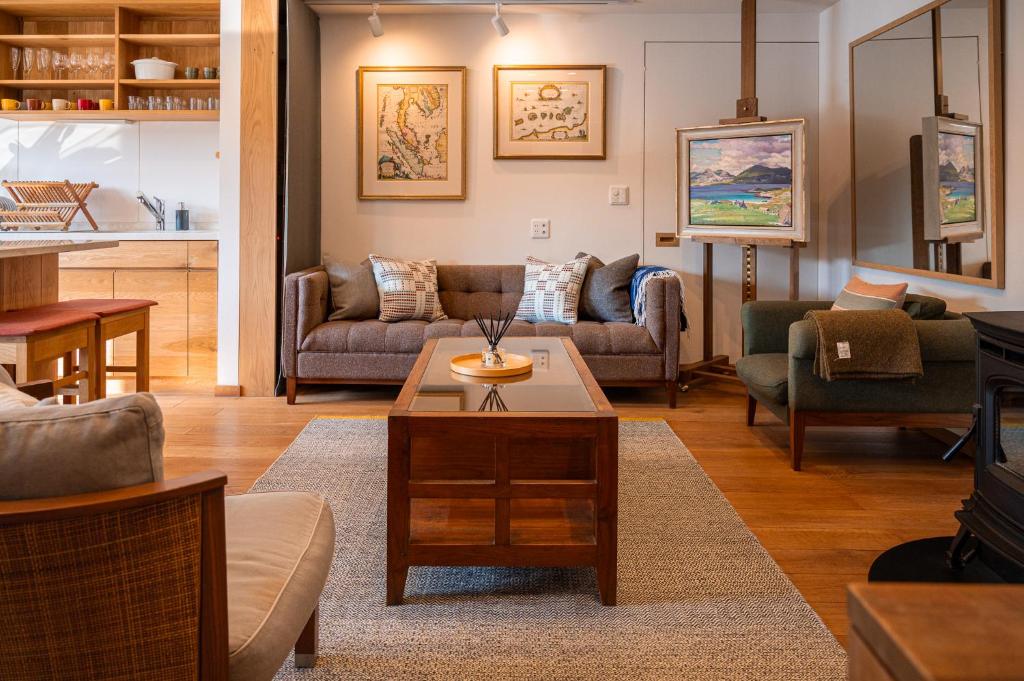 Kihachikan South Nozawa Onsen في نوزاوا أونسن: غرفة معيشة مع أرائك وطاولة قهوة