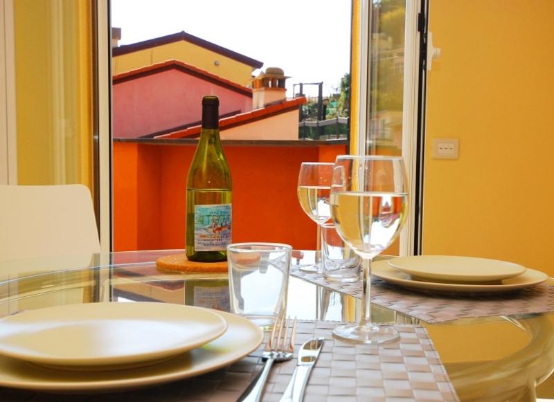 a glass table with a bottle of wine and glasses at Le Coste by Arbaspàa in Manarola