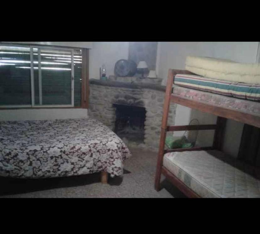 una camera da letto con camino, letto e scala di Rodolfo cabaña a Cosquín