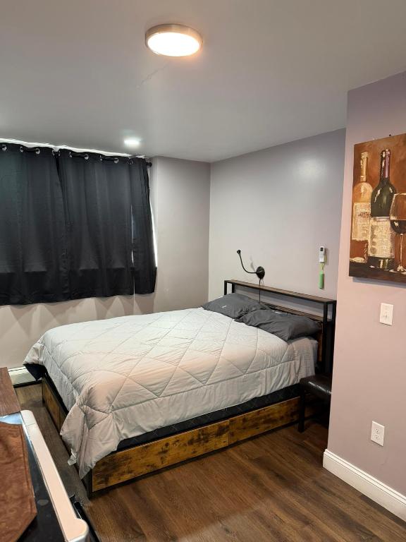 a bedroom with a bed and a window with wine bottles at Basement room with its own private bathroom in Providence