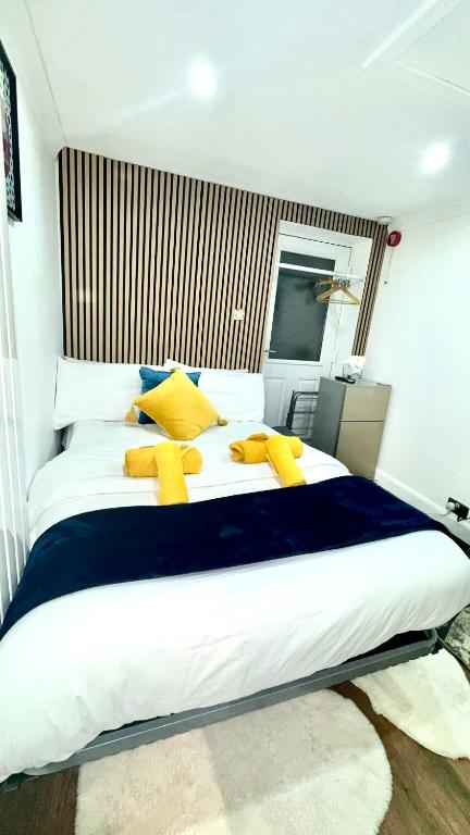 a bedroom with a large bed with yellow pillows at Kaira's Nook in Wolverton