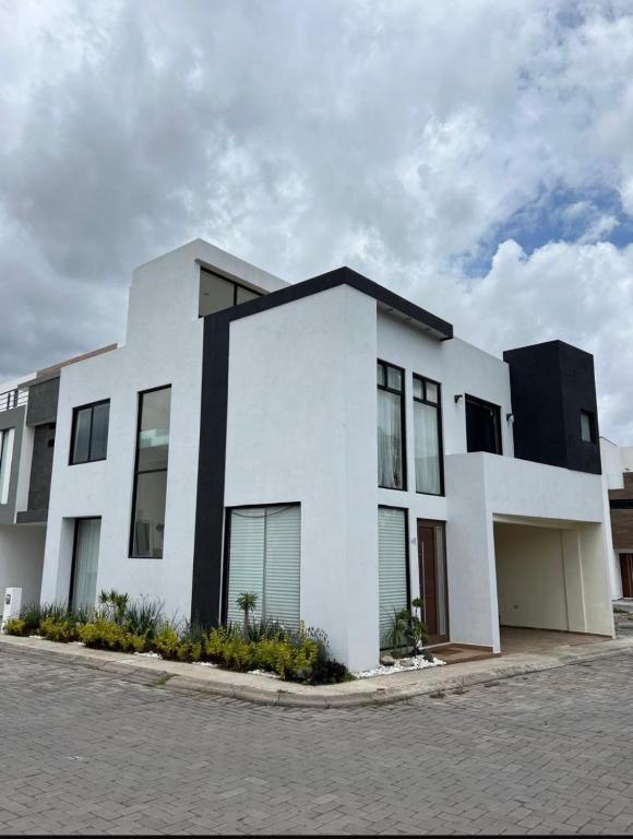 a white house with a black roof at Hermosa residencia en San Pedro Cholula in Cholula