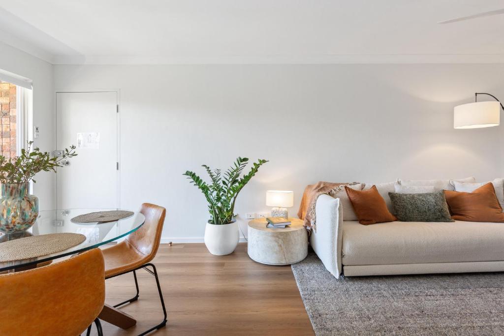 a living room with a couch and a table at Spacious Apartment Near Cronulla Beach in Cronulla