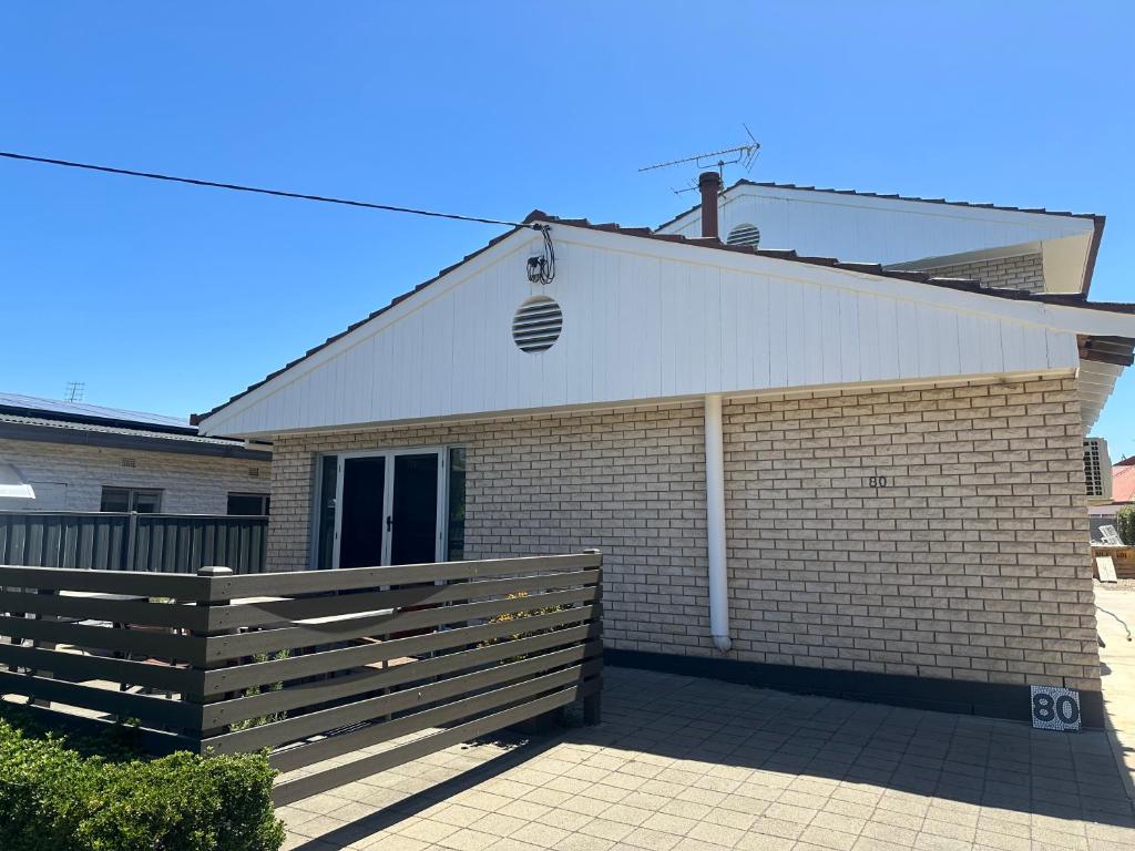 a white building with a fence in front of it at 80 Tarcutta St in Wagga Wagga