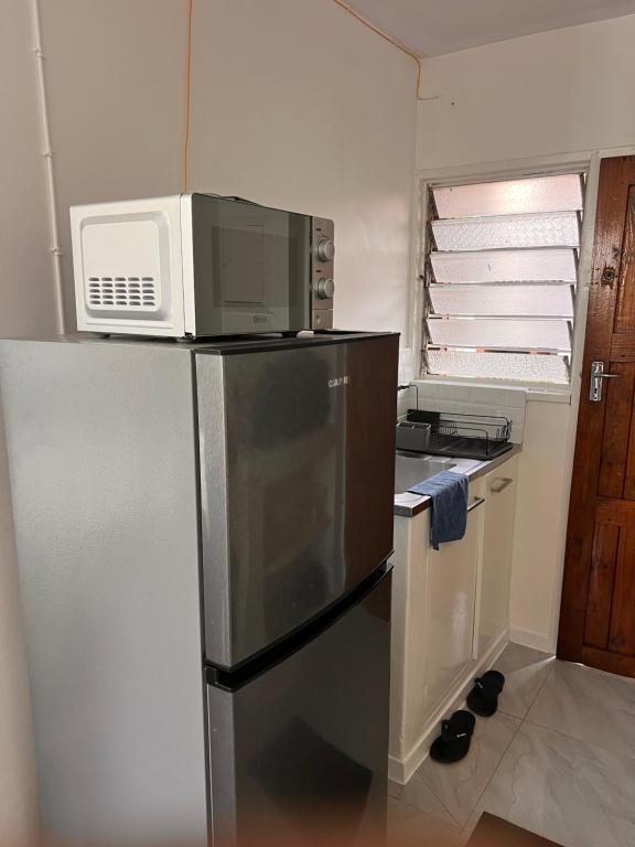una cocina con un microondas encima de un refrigerador en Lanina Harare Avenues Apartment, en Harare